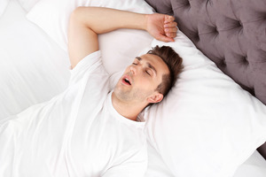 Man with sleep apnea snoring in bed